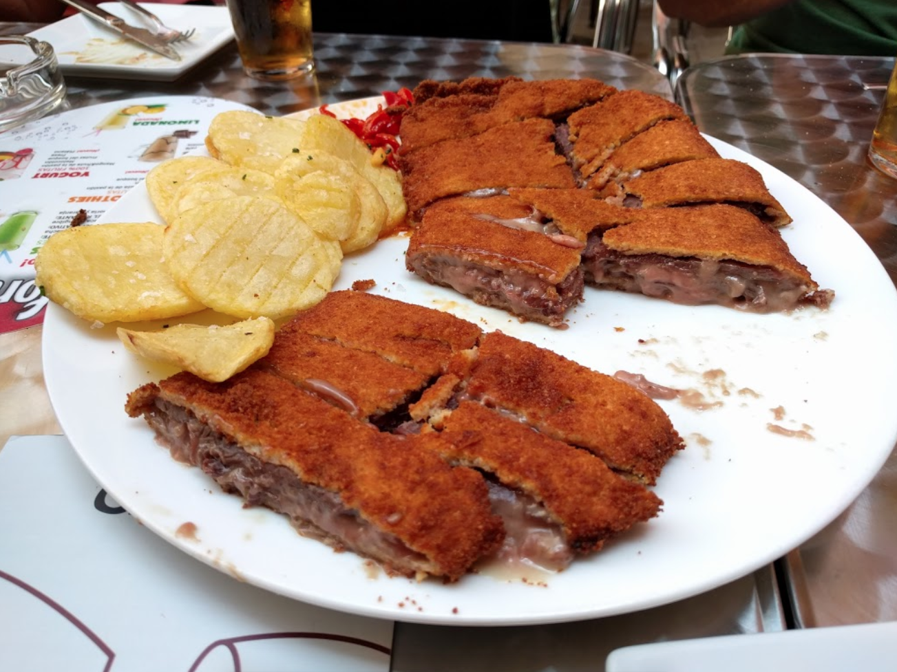 Cachopo Asturiano de ternera, relleno de cecina y queso de cabra con patatas y pimientos al ajillo - El Trassiego